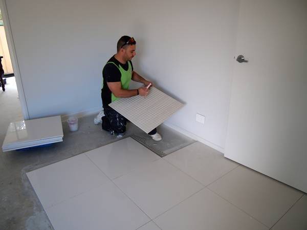 Man installing floor tiles